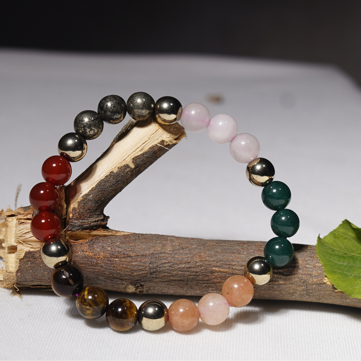 Colorful beaded bracelets on a piece of wood with a white background